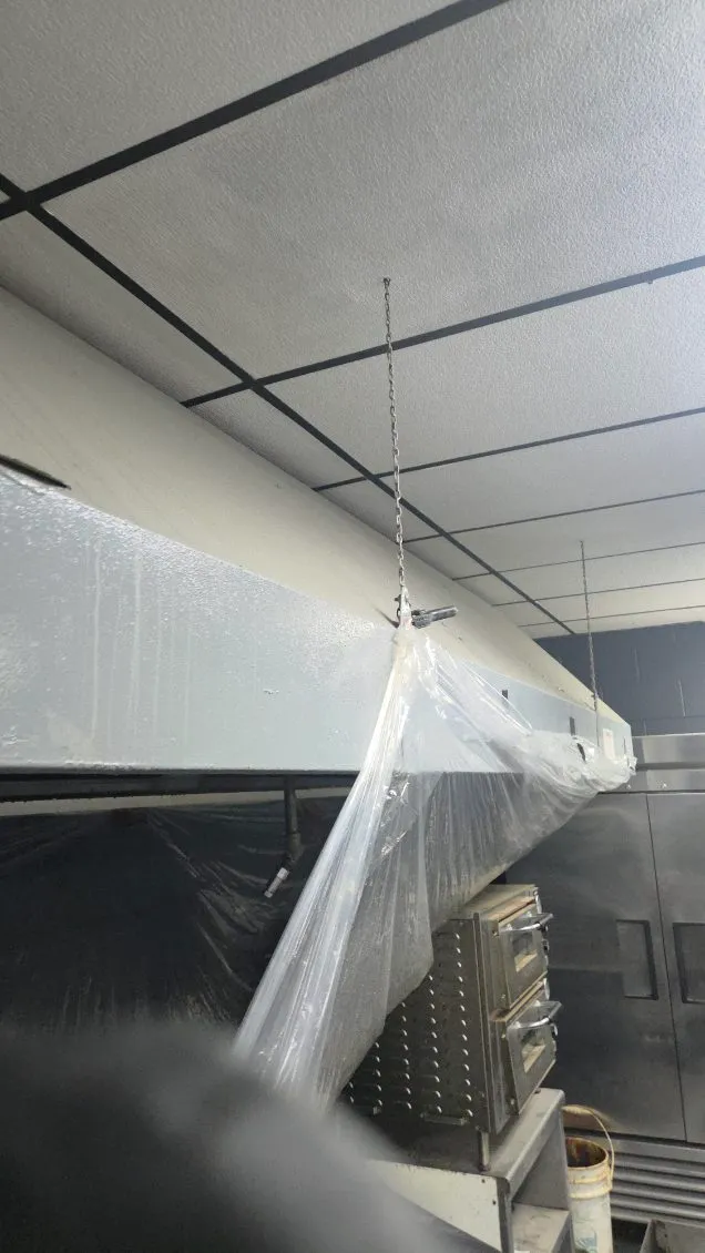 Commercial kitchen hood wrapped in plastic and ready for degreasing